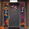 A dark gray door decorated with a Day of the Dead banner featuring skulls and vibrant floral motifs.