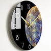A black round wall clock featuring a celestial design on the face and a modern glass panel on the left.