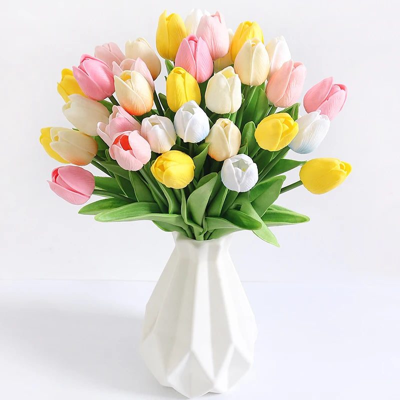 A bouquet of artificial tulip flowers in shades of pink, yellow, and white arranged in a white vase.