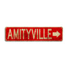 A rustic red metal sign with gold lettering spelling out AMITYVILLE and an arrow.