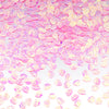 Pink and yellow sea shell PVC sequins scattered on a white background for nail art and craft decoration