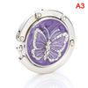 Silver foldable handbag hook with a purple marbled design and a butterfly motif
