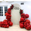 A display of ruby red balloons arranged in an arch shape against a light wall.