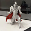A silver 3D printed knight figurine with a red cape, displayed on a white surface.
