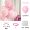 Pink latex balloons and accessories including a bow, a ring, and glue dots for decoration