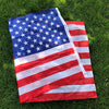 A folded American flag displayed on green grass.