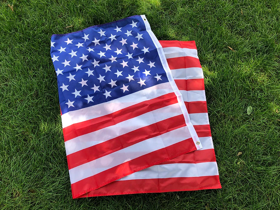 A folded American flag displayed on green grass.