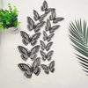 A collection of twelve black and white butterfly wall stickers arranged in a vertical pattern on a white background.