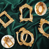 Various vintage gold DIY shadow box frames and decorative ornate gold picture frames displayed on a dark green velvet fabric.