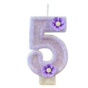 A purple sparkling number five candle decorated with small purple flowers.