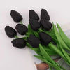 A bouquet of realistic artificial black tulips with green stems and leaves.