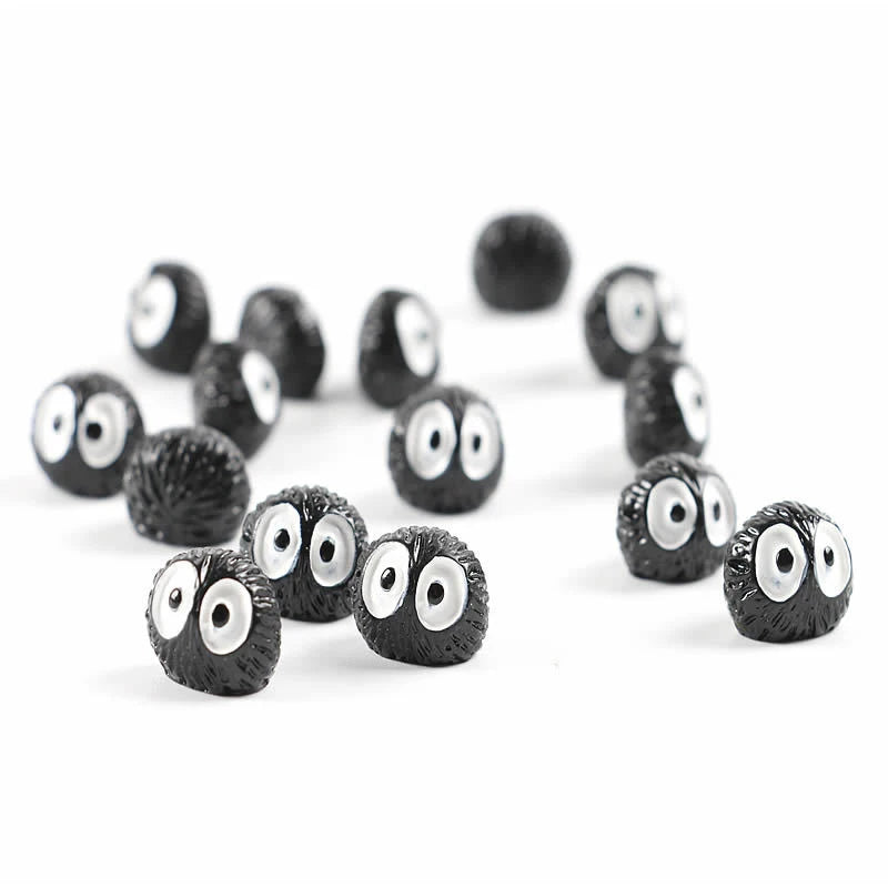 Collection d'ornements de voiture elfes noirs avec grands yeux blancs sur fond blanc.