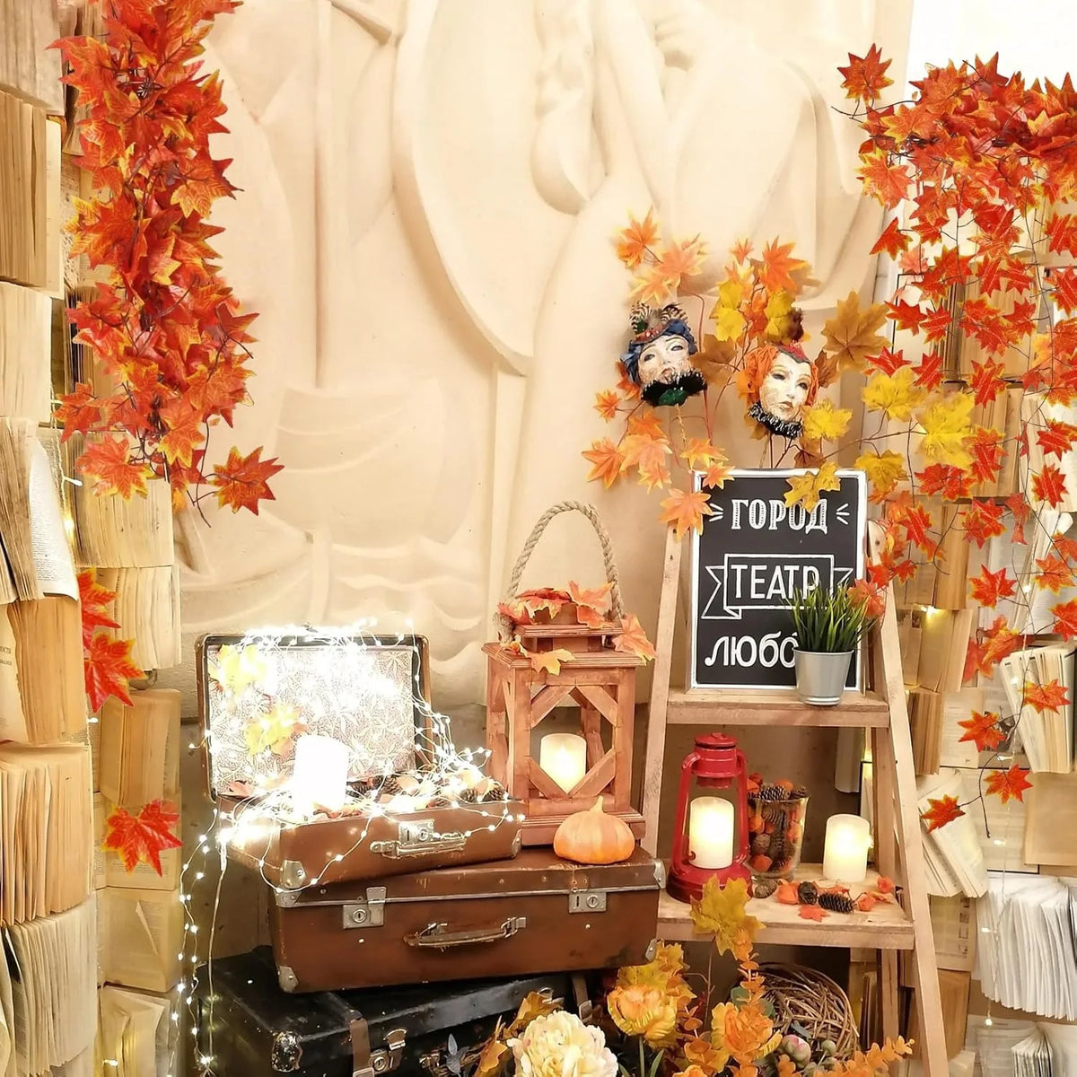 A display featuring an artificial maple leaf garland hanging vine decorated with autumn foliage and vintage props.