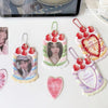 A collection of strawberry-themed bag keychains, card holders, and heart-shaped charms featuring pink, red, and green colors.