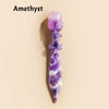 A purple amethyst crystal ball decorative piece with intricate carvings and a tapered shape.