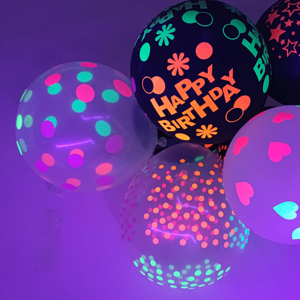 A cluster of neon glow-in-the-dark latex balloons in various bright colors, including pink, green, and orange, against a purp