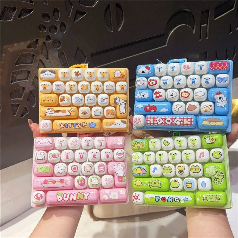 A hand holds a colorful keyboard keycap keychain featuring various cartoon animal designs and colors.