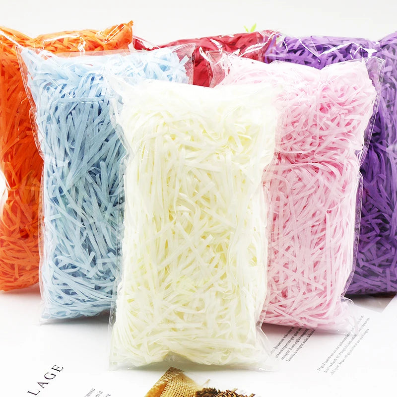 A collection of vibrant crinkle paper shreds in various colors including orange, blue, pink, and purple.