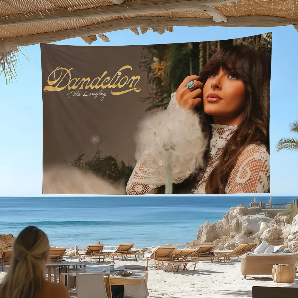 A portrait of singer Ella Langley in a sheer white lace top against a backdrop of the ocean and sky.