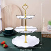 A set of gold and white decorative food trays for serving, including a stand and multiple serving plates.