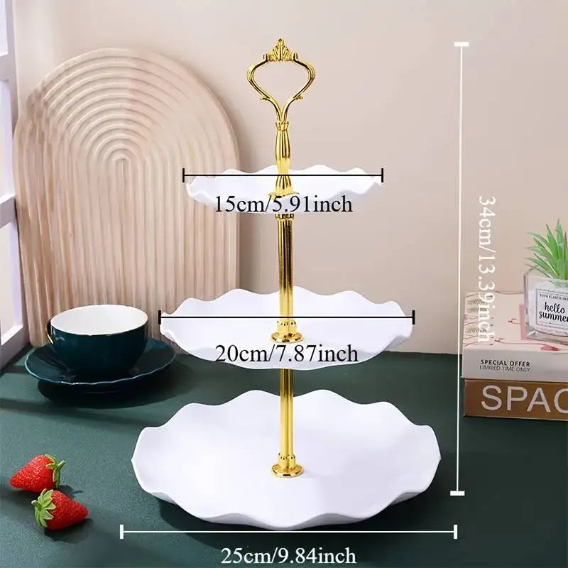 A set of gold and white decorative food trays for serving, including a stand and multiple serving plates.