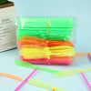 A clear plastic bag filled with colorful bamboo dragonfly flying propeller toys in various shades of green, yellow, and orang