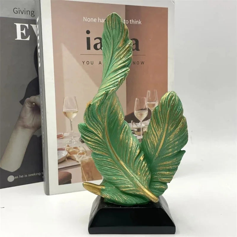 A vibrant green feather sculpture centerpiece with gold accents displayed on a black base.