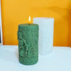 A green silicone candle mold shaped like a statue with a laurel wreath detail sits next to a white pillar candle on a yellow 
