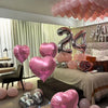 A display of pink and silver balloons decorating a room for a happy birthday celebration.