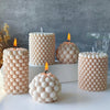 A collection of white Nordic bubble scented soy candles with flickering flames displayed on a gray background.