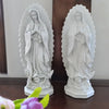 A pair of white resin statues depicting Our Lady of Guadalupe with rays of light.