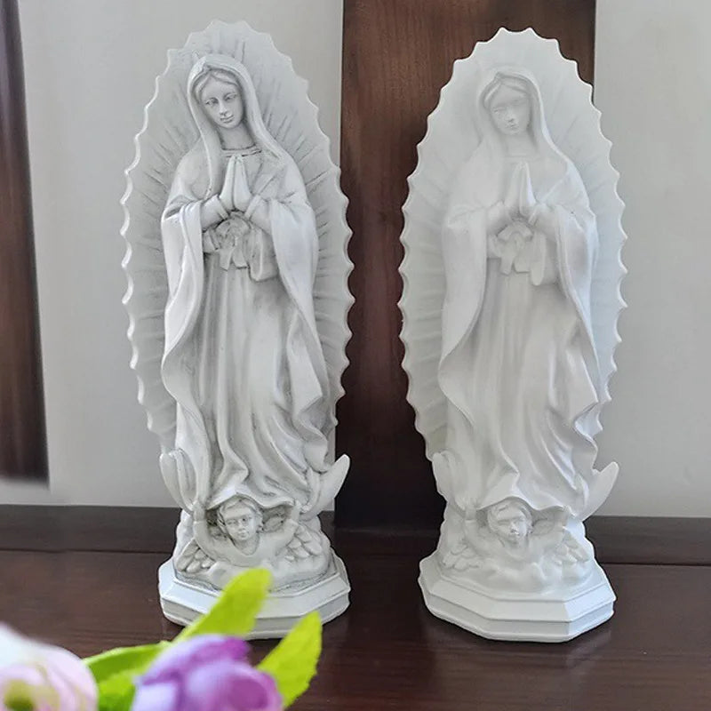 A pair of white resin statues depicting Our Lady of Guadalupe with rays of light.