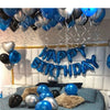 A silver and blue balloon decoration set with the words Happy Birthday hanging against a white wall.