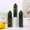 Three dark green emerald crystal point healing wands of varying heights displayed on a white surface.