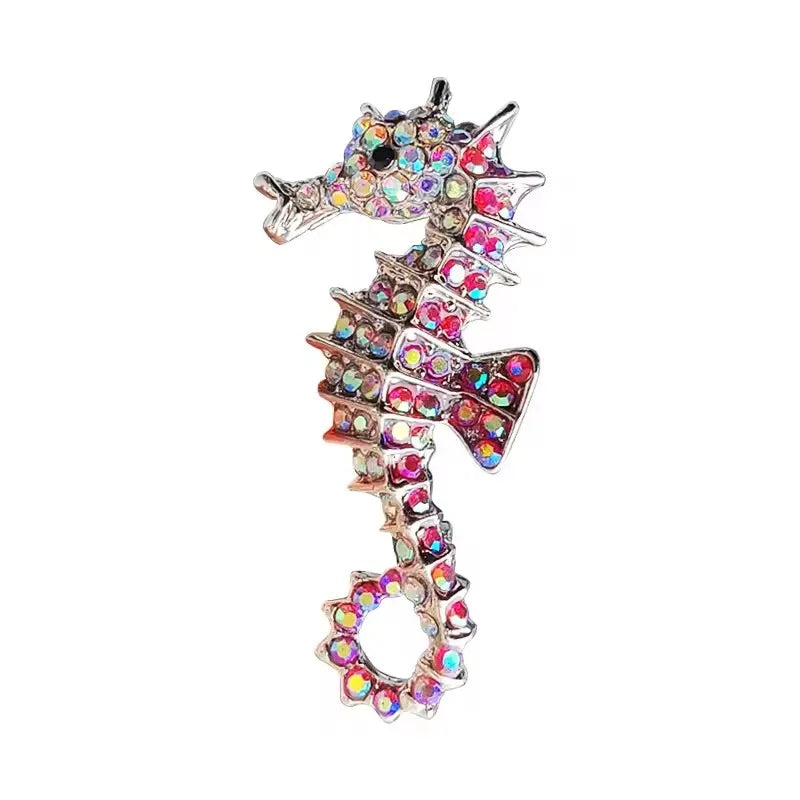 A vintage marine life brooch pin set featuring a silver-toned fish design encrusted with colorful rhinestones.