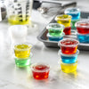 Une collection de gobelets en plastique jetables clairs avec couvercles de différentes couleurs vives, arrangés sur une surfa