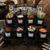 A collection of black witch cauldron mugs filled with various Halloween treats and candies for party favors