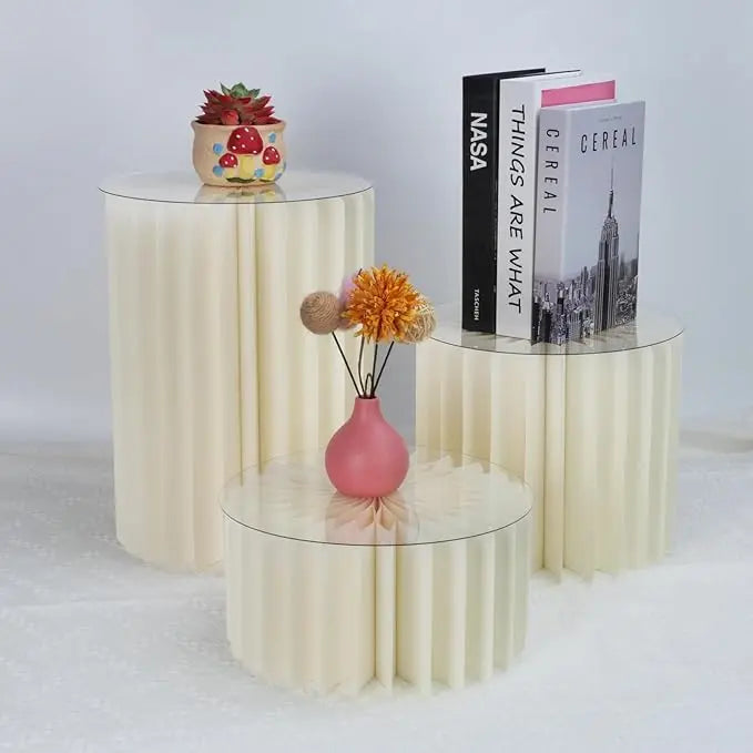 Supports alimentaires en acrylique présentant des livres et un arrangement floral sur une surface blanche.
