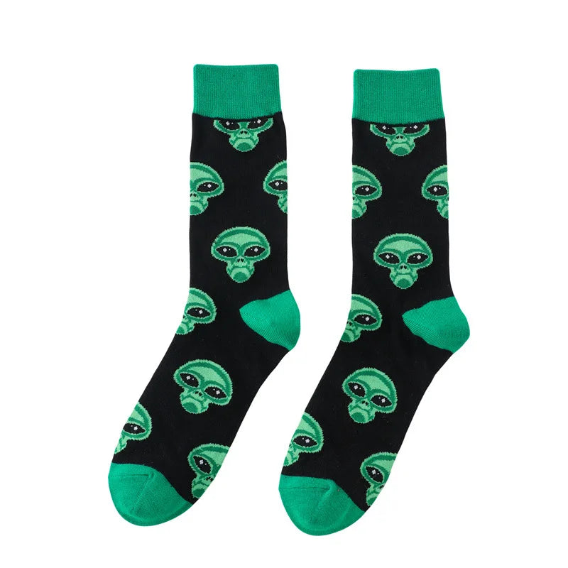 A pair of black crew socks with neon green trim featuring repeating alien skull patterns.