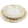 A stack of elegant white and gold polka dot disposable party tableware plates.