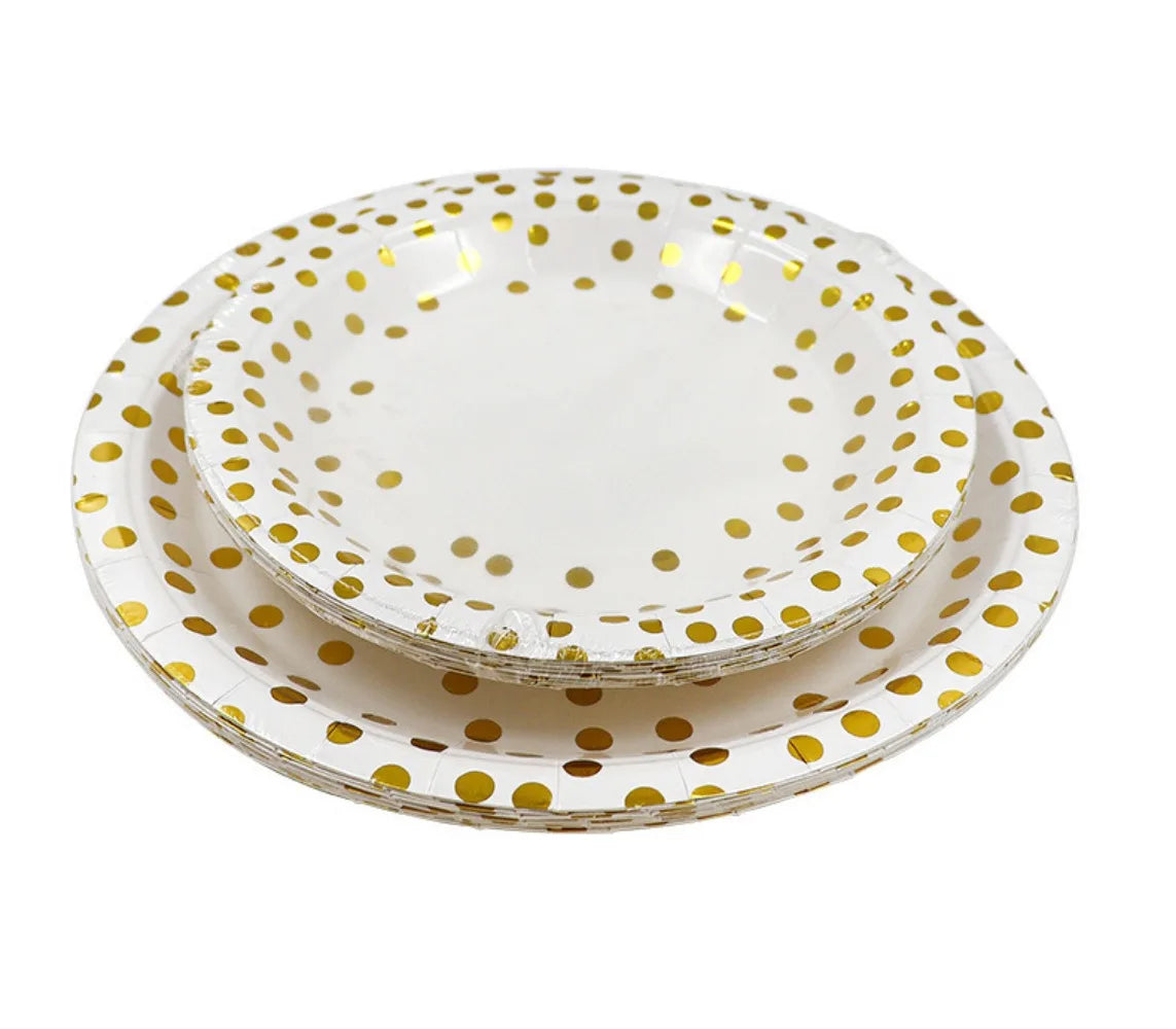 A stack of elegant white and gold polka dot disposable party tableware plates.