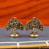 A pair of brass fortune tree ornaments with ingot accents resting on a dark surface.