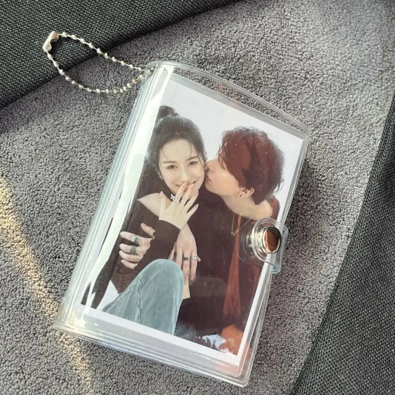 A clear plastic photo album with a silver chain attached, displaying a close-up portrait of two women.