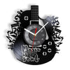A black wall clock shaped like a vinyl record featuring a guitar design and clock face.