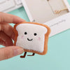 An adorable plush keychain charm shaped like a slice of toast bread with a smiling face.
