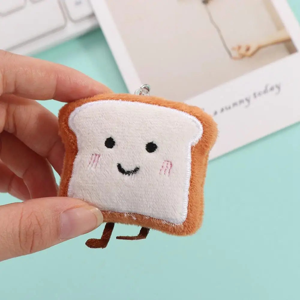 An adorable plush keychain charm shaped like a slice of toast bread with a smiling face.