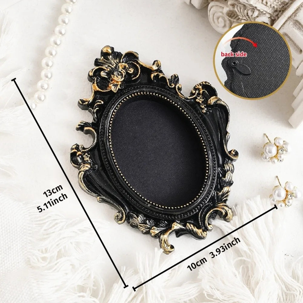 A black vintage baroque resin hanging photo frame displayed on a white surface with pearl accents.