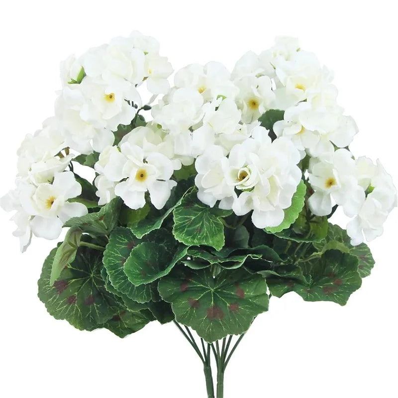 A bouquet of white faux silk geranium flowers with green leaves for outdoor and indoor decor.