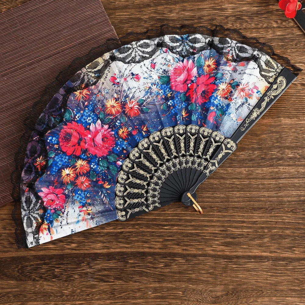 A Spanish style folding lace trim handheld fan featuring vibrant floral patterns and black detailing.