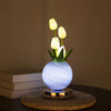 A white tulip LED night light with touch dimming is displayed on a woven mat.